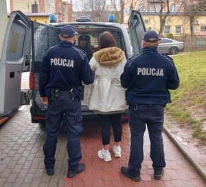 umundurowani policjanci z zatrzymaną kobietą