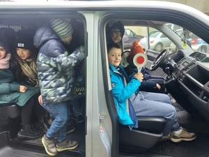 dzieci oglądają w środku policyjny radiowóz.