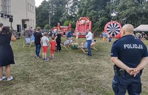 umundurowany policjant stoi na placu pikniku.