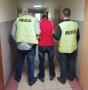 policjanci prowadzą zatrzymanego