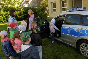 dzieci oglądają policyjny radiowóz.