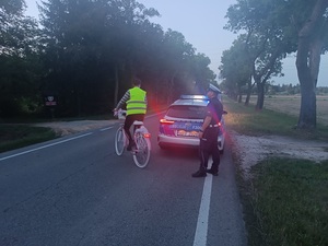 umundurowany policjant wręcza elementy odblaskowe.