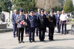 umundurowani policjanci składają kwiaty przed pomnikiem i oddają hołd.