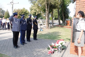 umundurowani policjanci składają kwiaty przed pomnikiem i oddają hołd.