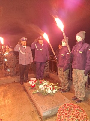 umundurowani policjanci oddają honory przed grobem Generała Krukowieckiego.