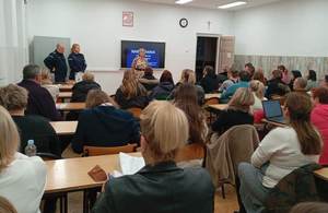 rodzice słuchają prelekcji prowadzonej przez umundurowanych policjantów.