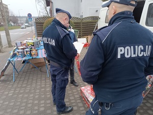 umundurowani policjanci sprawdzają stoiska z fajerwerkami.