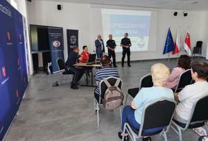 seniorzy słuchają wykładu prelegentów.