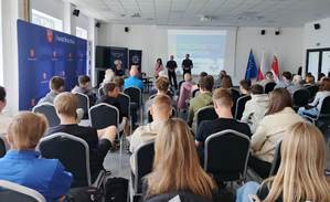 seniorzy słuchają wykładu prelegentów.