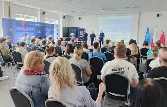 seniorzy słuchają wykładu prelegentów.