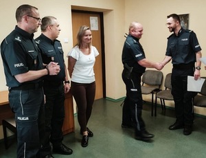 komendant wraz z przełożonymi wręcza akty mianowania wyróżnionym policjantom.