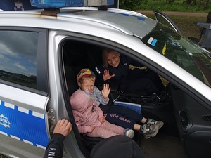 umundurowani policjanci w profilaktycznym namiocie udzielają porad i wręczają odblaski odwiedzającym gościom.