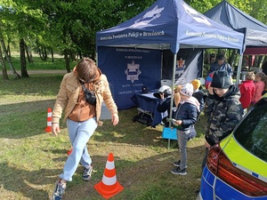 umundurowani policjanci w profilaktycznym namiocie udzielają porad i wręczają odblaski odwiedzającym gościom.
