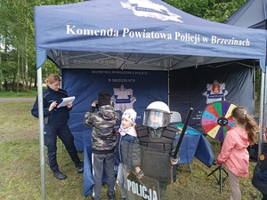 umundurowani policjanci w profilaktycznym namiocie udzielają porad i wręczają odblaski odwiedzającym gościom.