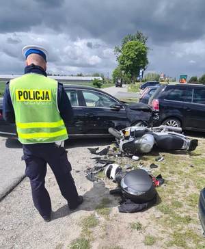 umundurowany policjant ruchu drogowego ogląda uszkodzone pojazdy.