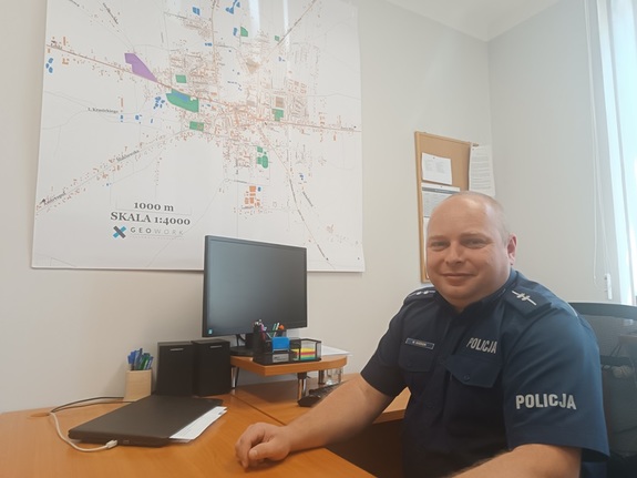 umundurowany policjant siedzi przy biurku.