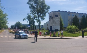 umundurowany policjant zabezpiecza przemarsz dzieci.