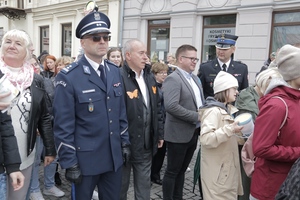 komendant w mundurze galowym idzie wraz z innymi uczestnikami przemarszu.