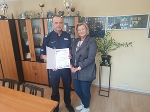 Pani dyrektor stoi wraz z komendantem do wspólnego zdjęcia.