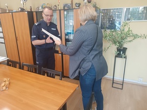 Pani dyrektor wręcza komendantowi podziękowania.