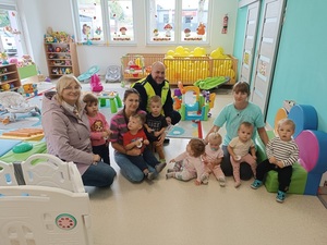 maluszki pozują do zdjęcia z umundurowanym policjantem.