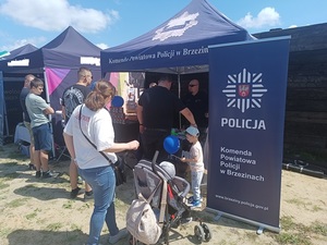 grupka osób odwiedzających policyjny namiot.