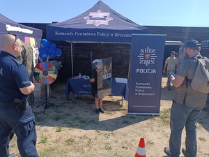 grupka osób odwiedzających policyjny namiot.