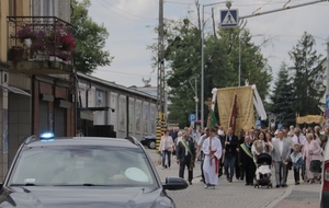 nieoznakowany radiowóz z włączonymi światłami błyskowymi jedzie na czele procesji.