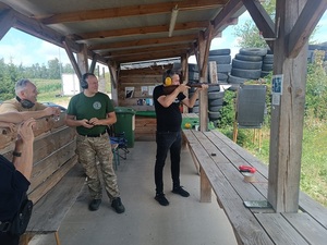 uczestnicy strzelania pod okiem instruktora.