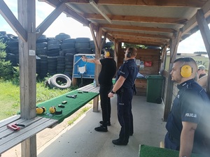 uczestnicy strzelania pod okiem instruktora.