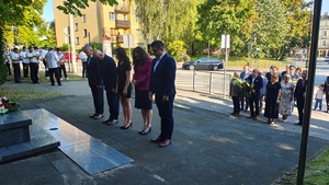 zebrani goście oddają hołd przed pomnikiem marszałka.