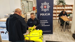 umundurowany policjant rozmawia z seniorami.