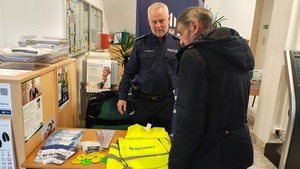umundurowany policjant rozmawia z seniorami.
