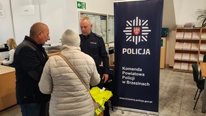 umundurowany policjant rozmawia z seniorami.