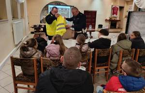 umundurowani policjanci prowadzą prelekcję dla młodzieży.