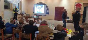 umundurowani policjanci prowadzą prelekcję dla młodzieży.