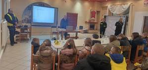 umundurowani policjanci prowadzą prelekcję dla młodzieży.