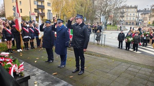 delegacja służb mundurowych składa kwiaty i oddaje honory pod pomnikiem Marszałka.