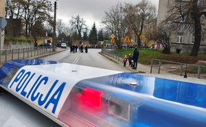uczestnicy uroczystości w asyście policji idą ulicami miasta.
