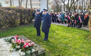 delegacja mundurowa składa kwiaty pod tablicą ojców narodu.