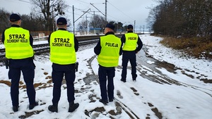 umundurowani policjanci i umundurowani strażnicy ochrony kolei kontrolują infrastrukturę kolejową.