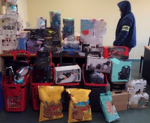 Nieumundurowany policjant wraz z zabezpieczonymi przedmiotami.