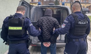 Umundurowani policjanci z osobą zatrzymaną.