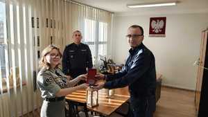 Przekazanie pamiątkowego medalu przez Komendanta.