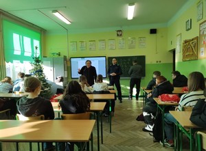 Umundurowany policjant omawia kwestie bezpieczeństwa.