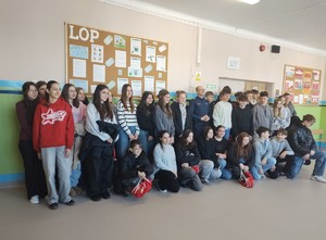 Grupa wolontariuszy pozuje do zdjęcia z umundurowanym policjantem.