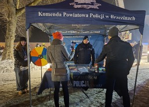 Osoby przy policyjnym stoisku.