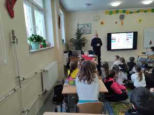 Umundurowany policjant prowadzi prelekcje.