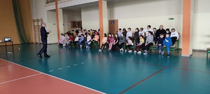 Policjant prowadzący spotkanie w szkole z dziećmi.