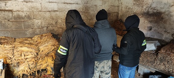 Nieumundurowani funkcjonariusze wraz z osobą zatrzymaną na miejscu prowadzenia działań.